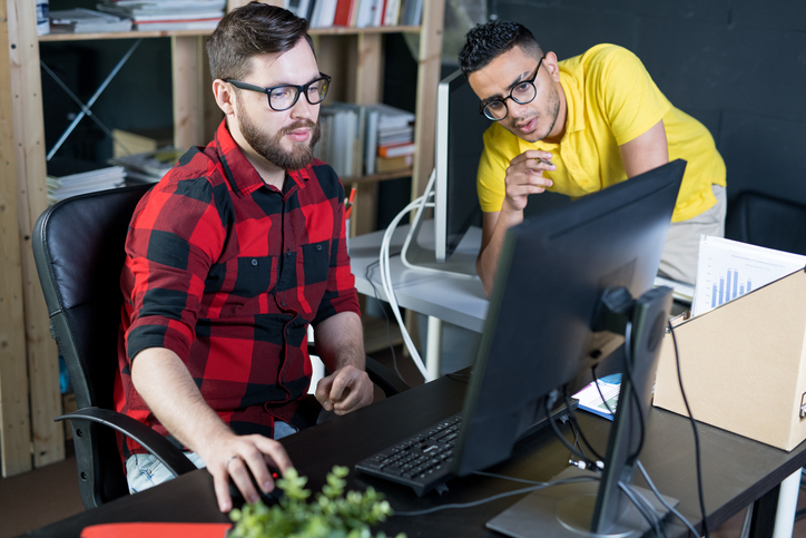 Two men using a computer to work