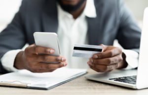 Businessman making an online payment using his smartphone, closeup