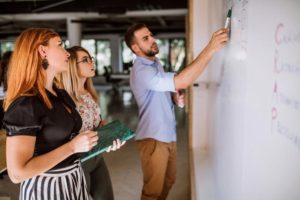 group-of-professionals-surrounding-whiteboard