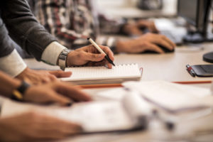 man writing in a notepad