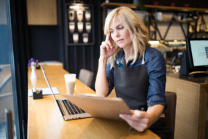 Coffee shop owner working on laptop