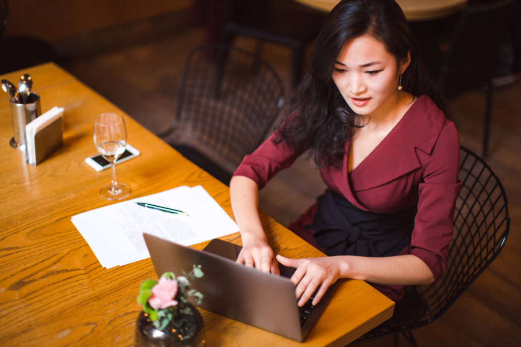 Businesswoman working on laptop and some paperwork