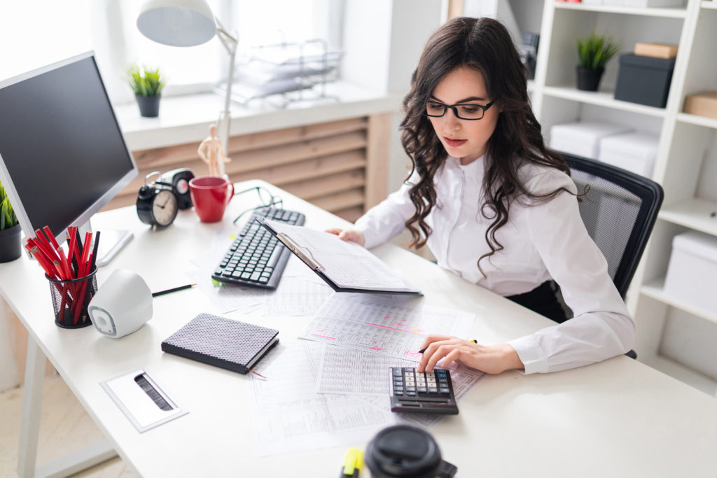 A young woman is working in a bright office