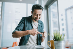 Adult Man Depositing Check With Smartphone