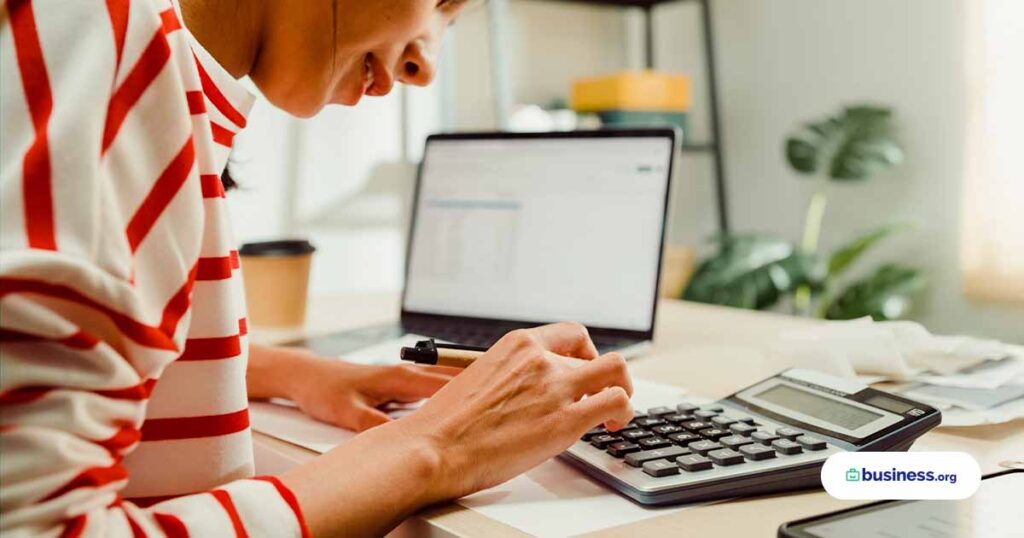 Close-up Young Asian woman with sweater sit front desk with laptop use calculator calculate to utility bills check credit card receipt monthly expense bill at house. Close-up Young Asian woman with sweater sit front desk with laptop use calculator calculate to utility bills check credit card receipt monthly expense bill at house. Home financial lifestyle concept. Calculator Stock Photo