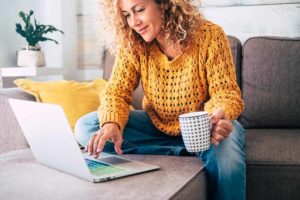 woman-sitting-on-couch-with-laptop