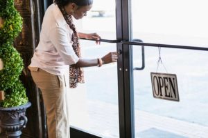 African-American woman opening store, unlocking the door
