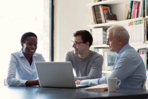 group-of-three-business-people-around-a-laptop