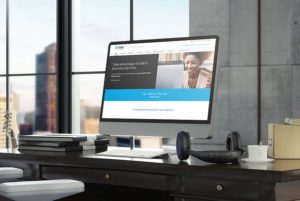 Workplace desk with AT&T page open on monitor