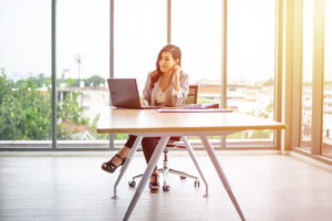 Featured image of a young business professional sitting at a desk, talking on the phone