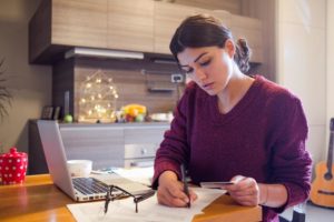 young woman paying bills from home