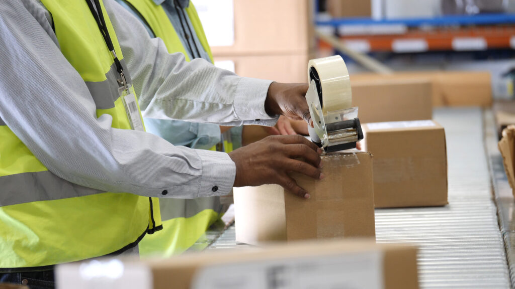 Warehouse employees preparing a package for distribution