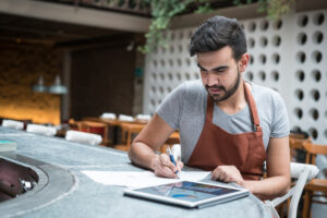 Feature image of a Latino businessman running numbers on his tablet