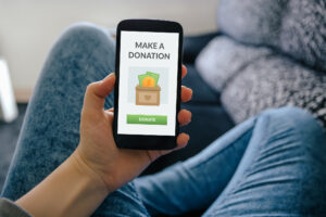 Feature image of a woman holding a phone with the text make a donation