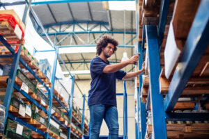 A man using a barcode scanner on boxes in a warehouse