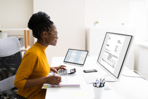 Feature image of a young Black woman looking at an invoice on her computer