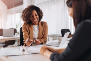 Feature image of a woman smiling across a table at another woman