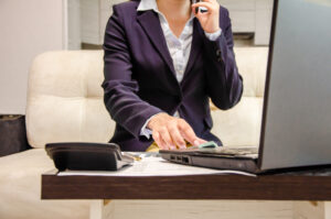 Feature image of a businesswoman typing on a laptop with a calculator to one side