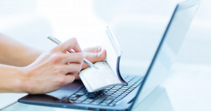 Close up image of a white woman's hands holding a checkbook