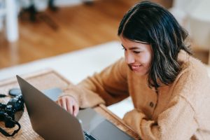 Woman smiling at a laptop on a desk