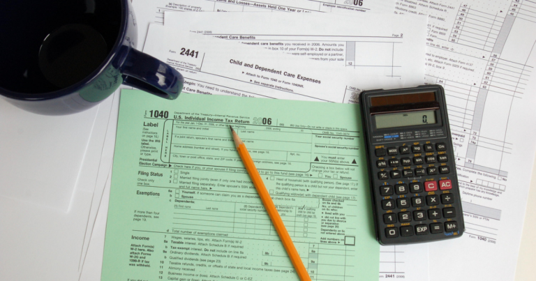 Green tax form 1040 beneath a pencil and calculator
