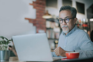 Small business owner reviewing local SEO on his laptop in a cafe