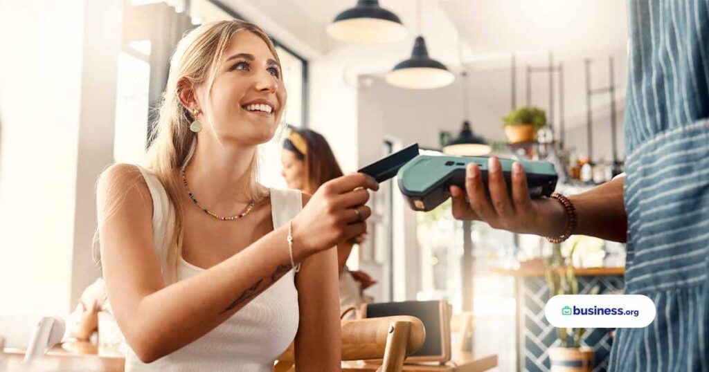 Shot of a young woman making a card payment using a nfc machine stock photo