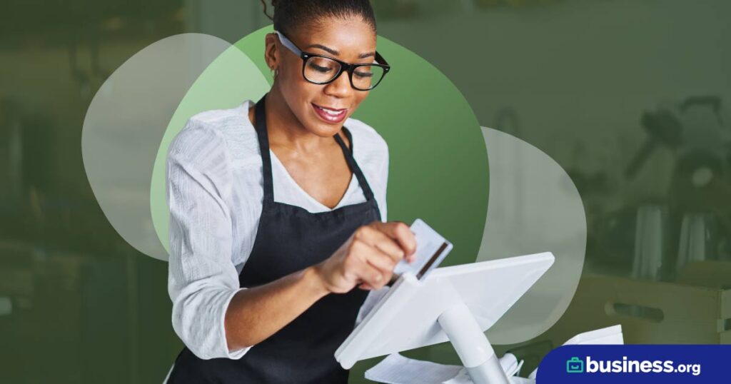 women with apron swiping credit card to card for payment