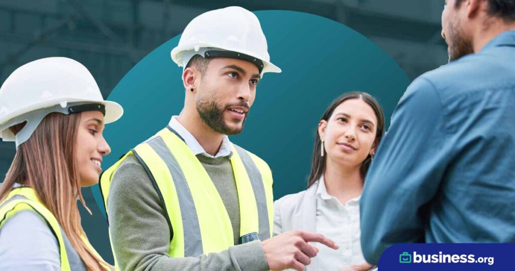 women and a man wearing construction safety gear interacting with another man and women.