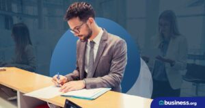 person sitting at desk filling out paperwork on abstract background