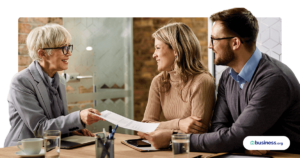 happy couple working with woman wearing glasses going over paperwork
