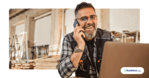 construction worker talking on phone while using laptop