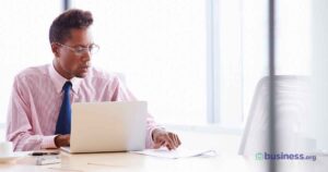 male-using-calculator-sitting-at-desk