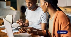 two people using calculator and laptop