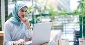woman wearing a headscarf working on a laptop