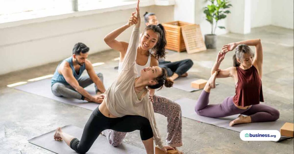 yoga-instructor-showing-client-how-to-deepen-pose